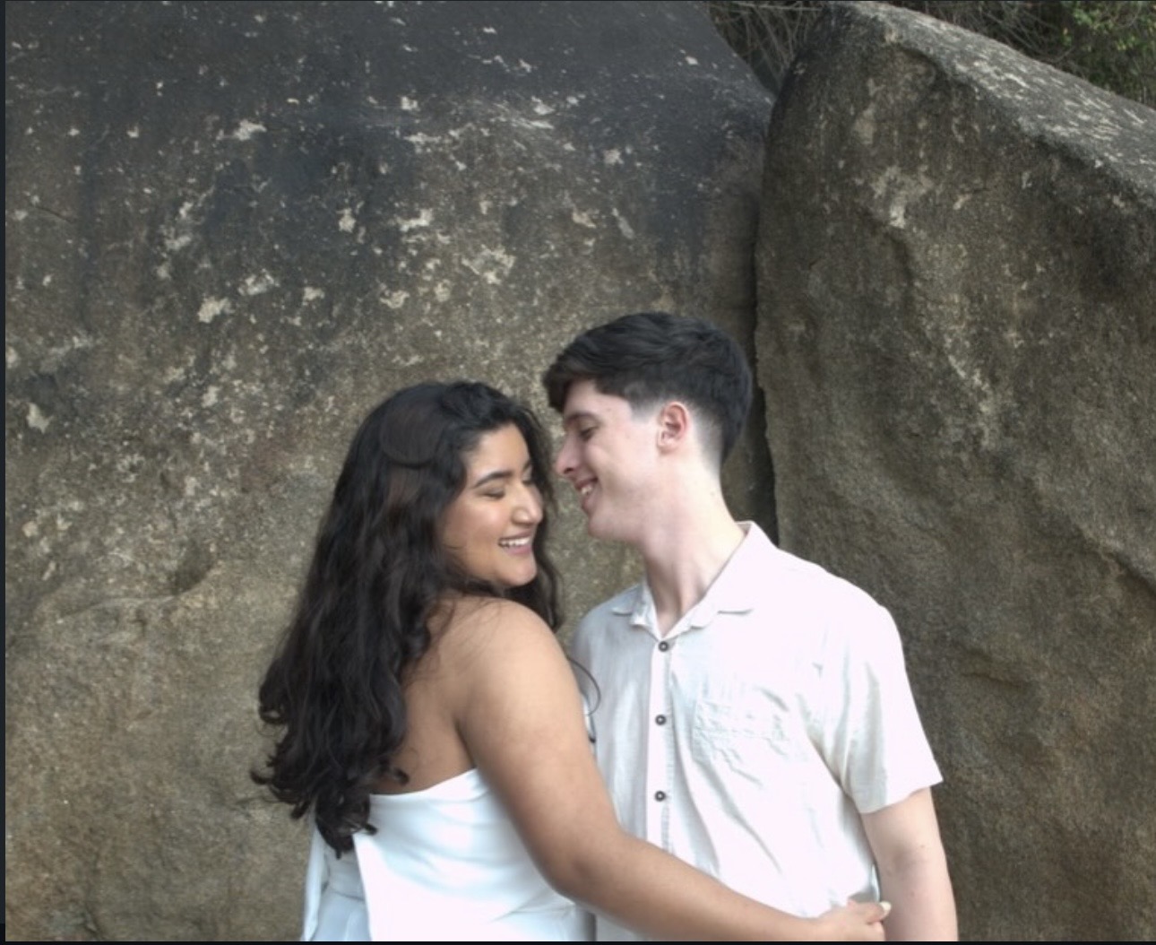 Gabriela e Kauan abraçados diante de uma pedra
